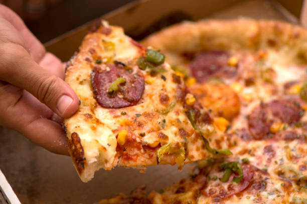 Woman's Hand Taking Slice Of Pizza