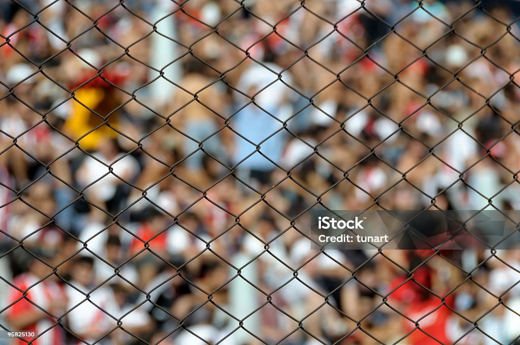 Il pubblico in uno stadio dietro barriera - Foto stock royalty-free di Barriera