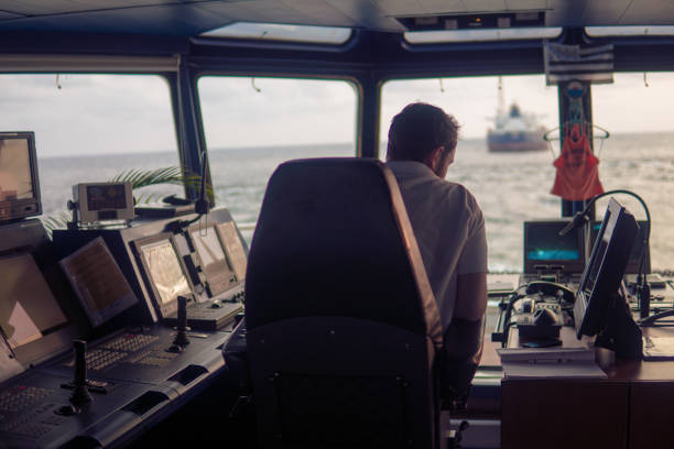 Deck navigation officer on the navigation bridge. He looks at radar screen. Watchkeeping, collision prevention at sea. COLREG