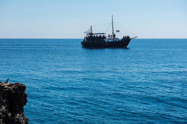 istock Pirate ship sailing in the sea. View from a cave 958259386