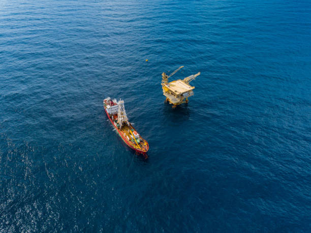 istock Soil Boring Boat (a geotechnical drilling cum analogue survey vessel) close to a oil platform 958271578