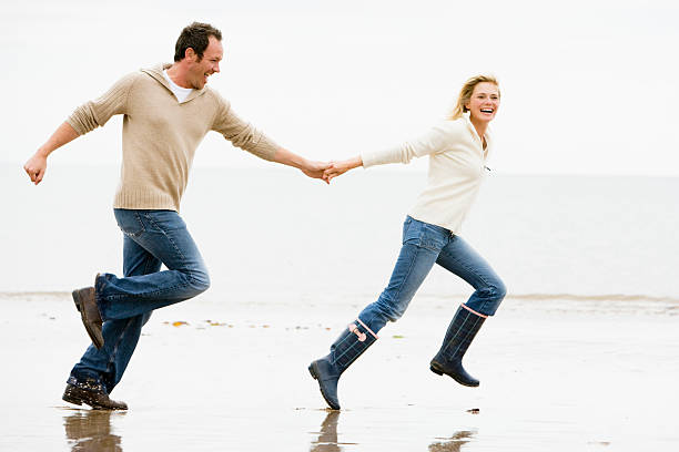 istock Couple running on beach holding hands 95827237