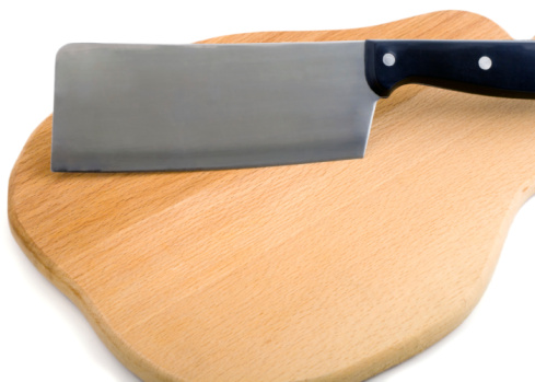 round cutting board with knife on white table
