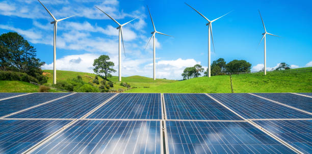 istock Solar panel and wind turbines farm on green hills. 958279512