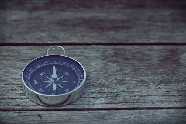 istock Compass on old wooden table background, journey planning concept, vintage tone 958295356