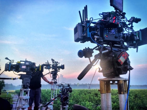 A group of four motion picture cameras set up for a sunrise shot.