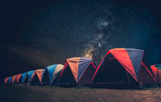 Glowing tent in the mountains under a starry sky