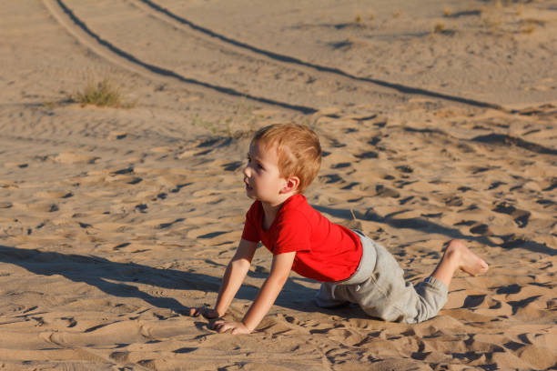 istock A boy on a yellow sand in sunset time 958317688