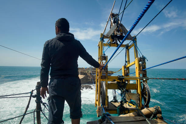istock Man holding transport mechanism while looking into the rough sea 958318446