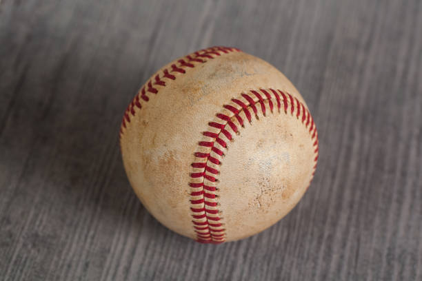istock worn baseball on the wooden Table, sport 958325688