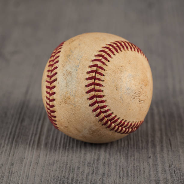 istock worn baseball on the wooden Table, sport 958325694