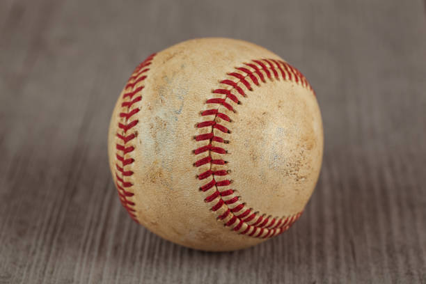 istock worn baseball on the wooden Table, sport 958325722
