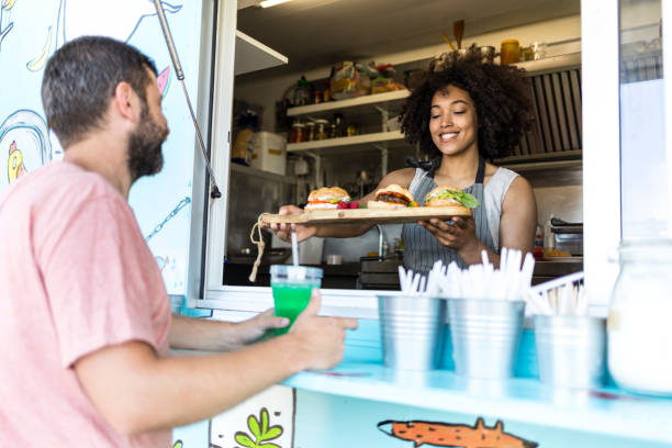 istock Customer taking burgers from food van 958326328