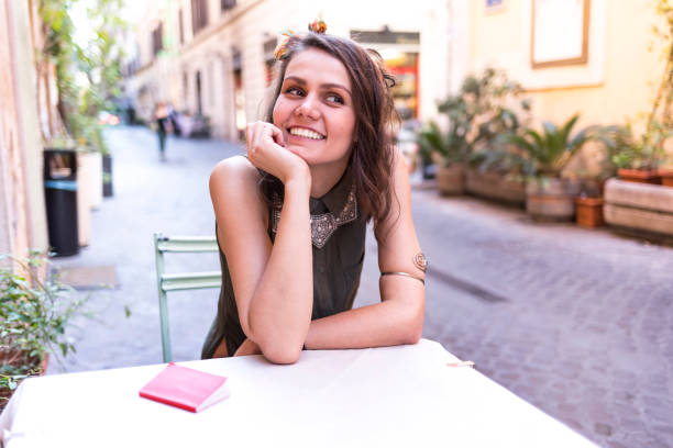 istock Smiling tourist sitting in sidewalk cafe in Rome 958326410