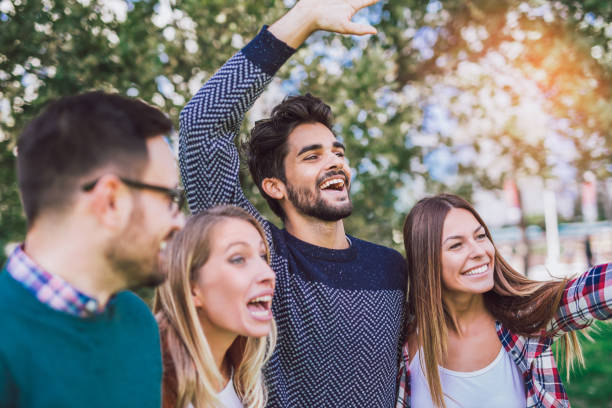istock Group of young people walking through park 958327196