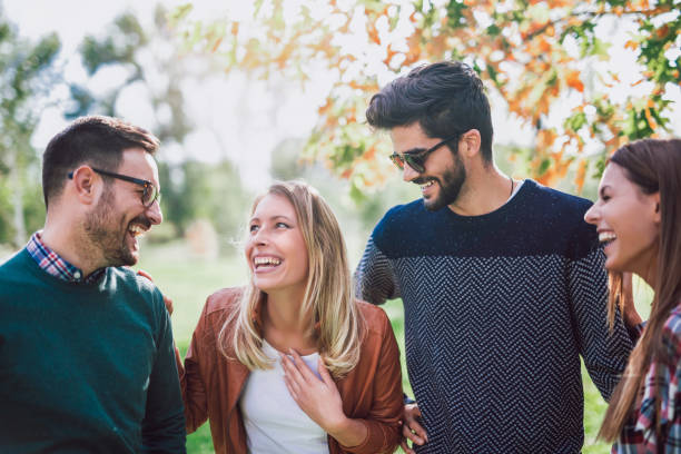 istock Group of young people walking through park 958332208