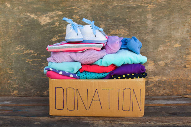 istock Donation box with children's things on wooden background. 958332484