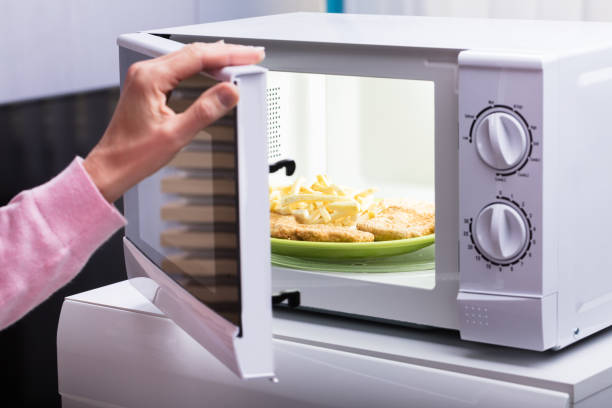 femme de chauffage des aliments frits au four à micro-ondes - timer cooking domestic kitchen time photos et images de collection