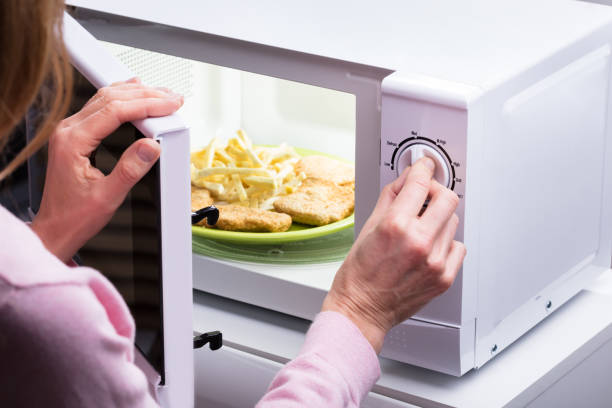femme chauffage aliments au micro-ondes - timer cooking domestic kitchen time photos et images de collection
