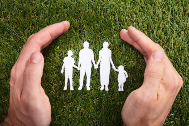 istock Human Hand Protecting Family Paper Cut Out 958335610