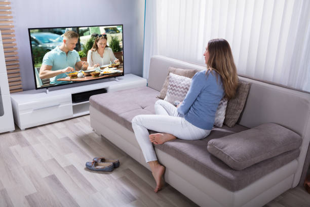 istock Woman Watching Television At Home 958336150