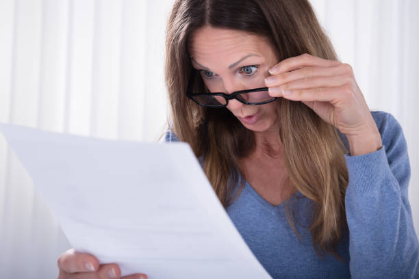 istock Shocked Woman Looking At Document In Office 958336196