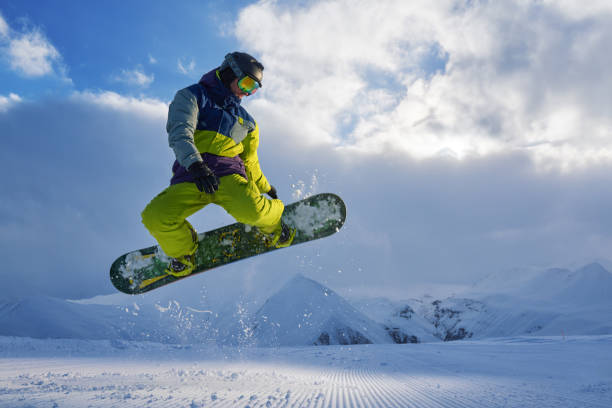 istock snowboarder does the jumping trick. snow scatters pieces 958336762