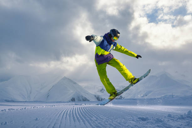 istock snowboarder does the jumping trick. snow scatters pieces 958336804