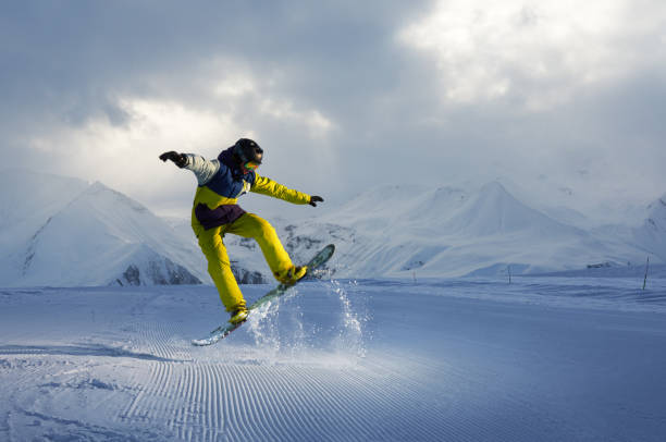 istock snowboarder does the jumping trick. snow scatters pieces 958339200