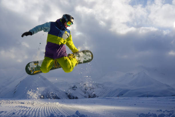 istock snowboarder does the jumping trick. snow scatters pieces 958339258