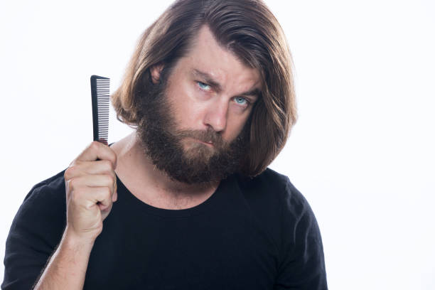 istock Man combs his hair with comb brush isolated on white background 958339844