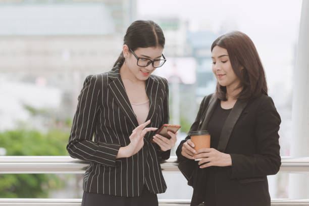 istock Two beautiful confident asian business woman taking a coffee break during break time. 958343420
