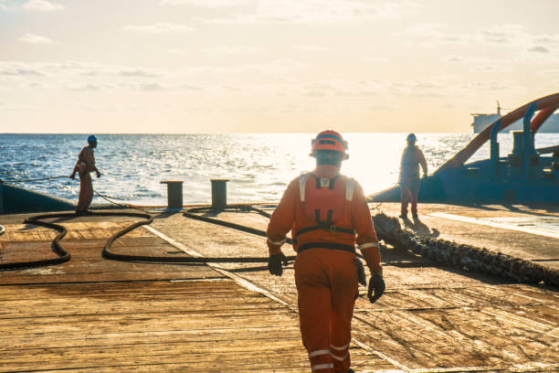 AHTS vessel doing static tow tanker lifting. Ocean tug job Anchor-handling Tug Supply AHTS vessel crew preparing vessel for static tow tanker lifting. Ocean tug job. 3 AB and Bosun on deck. Good teamwork drill team stock pictures, royalty-free photos & images