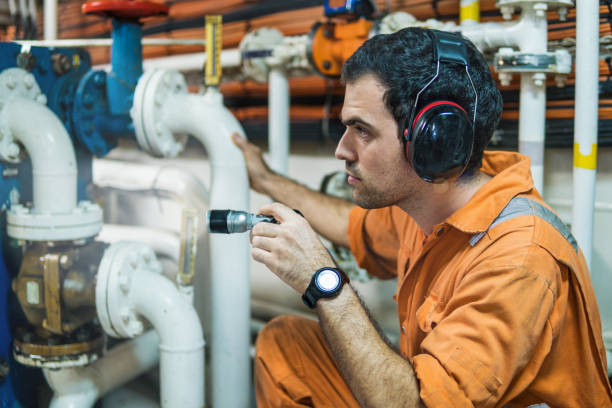 marine engineer inspecting ship's engine in engine control room - vessel part imagens e fotografias de stock