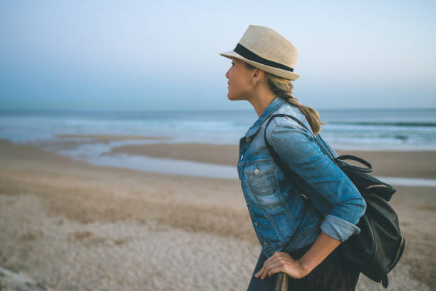 istock Young woman with backpack on the beach 958358508