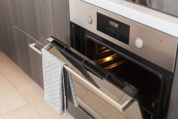 istock Opened oven with grey towel hanging on it 958371210