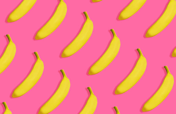 istock Yellow bananas pattern on vivid pink background, top view. 958371248