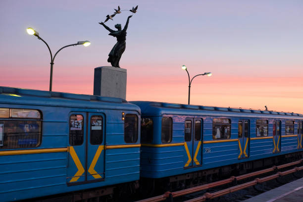 киевская станция метро днепр. поезд метро против неба. люди собираются работать в метро - europe bridge editorial eastern europe стоковые фото и изображения