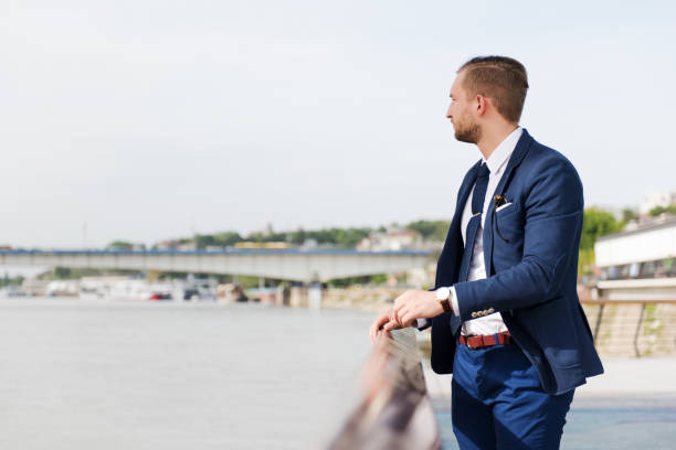 istock Handsome elegant businessman enjoys a sunny day by the river 958380704
