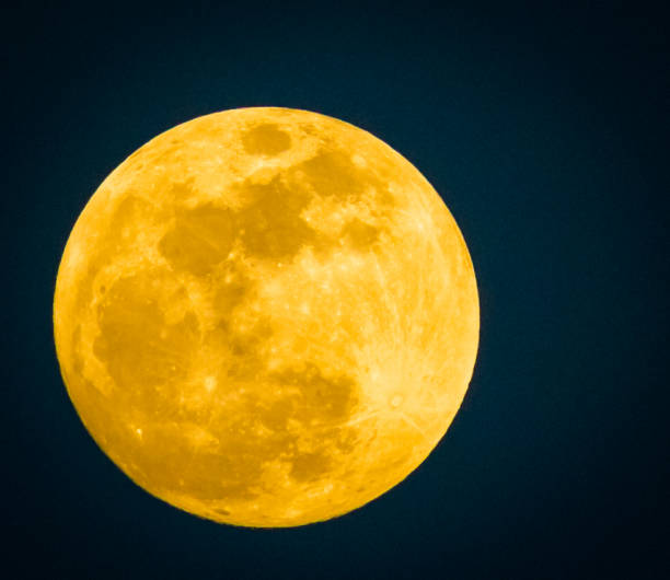 istock An extremely large yellowish full moon sits by itself in the night sky 958384930