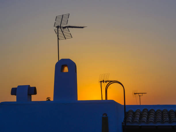 istock Analogue antenna on roof at sunset 958391530