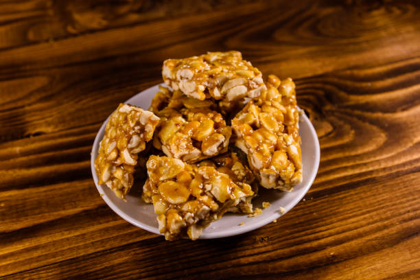 istock Ceramic plate with peanut brittles on wooden table. 958392022