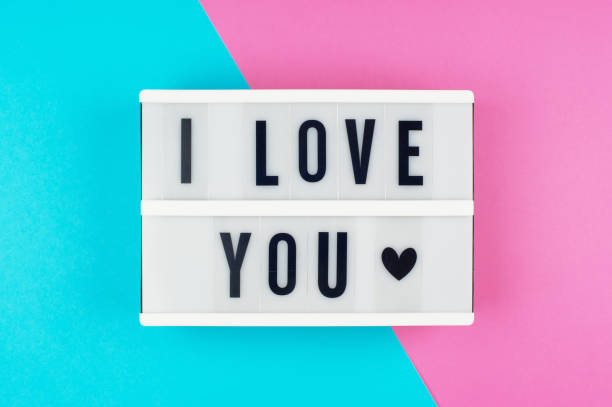 istock I Love You - text on a display lightbox on blue and pink bright background. 958396312