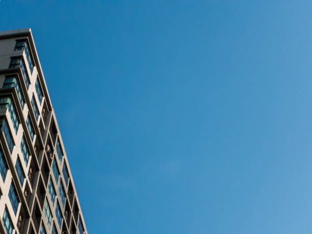 istock uprisen angle - building in the city on blue sky background 958399470