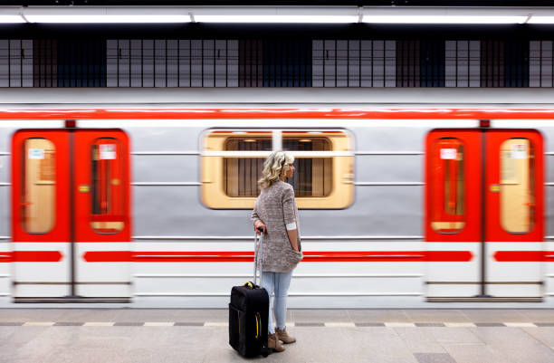 istock Young woman with suitcase waiting train in metro station. 958399586