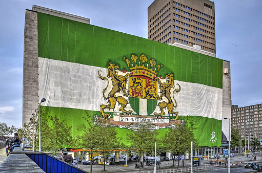 Rotterdam, The Netherlands, May 6, 2017: an enormous flag with the city's blazon decorates an office building to celebrate football club Feyenoord's winning the league