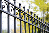 Beautiful decorative cast metal wrought fence with artistic forging. Iron guardrail close up.