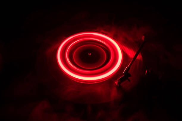 istock Turntable playing vinyl with glowing abstract lines concept on dark background 958412254