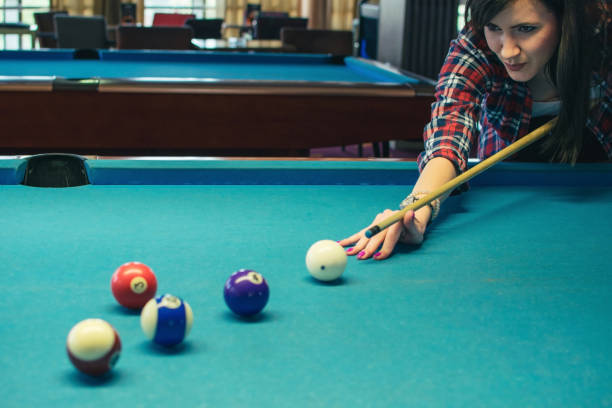 istock Young woman playing pool game in pub 958420296