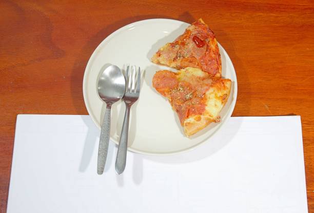 Two pizzas in white plate and white background and wooden plate.